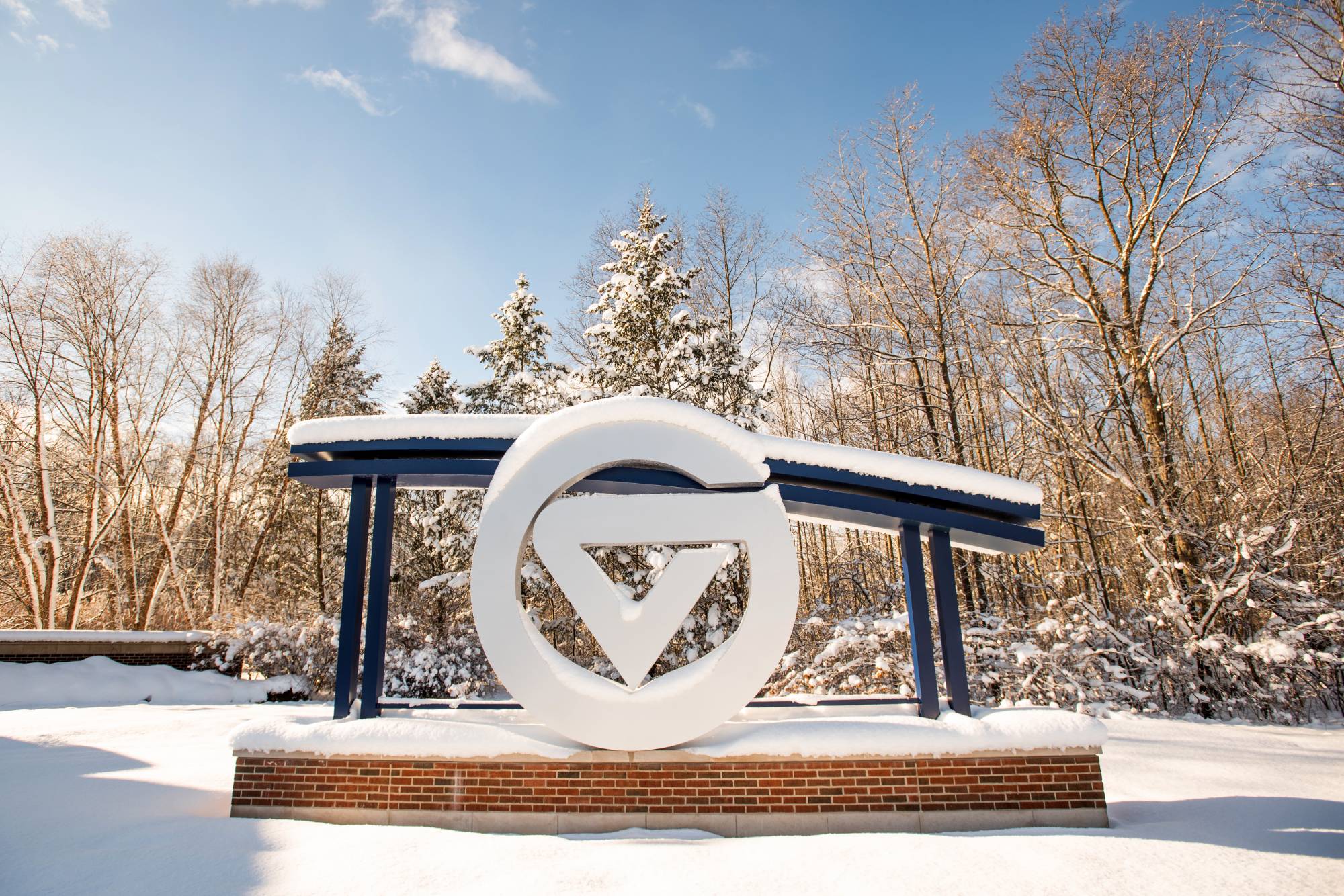 The sign at the entrance to GVSU's Allendale Campus on a snowy, sunny day.